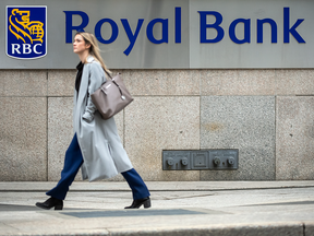 Young woman waks in front of Royal Bank sign