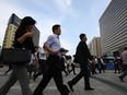 Morning commuters and pedestrians walk through Gwanghwamun square in Seoul, South Korea.