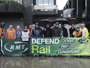 Mick Lynch, general secretary of the Rail, Maritime and Transport union (RMT), sixth left blue jacket, joins union members on the picket line during a rail strike in a long-running dispute over jobs and pensions, outside Euston station in London, Saturday March 18, 2023. Tens of thousands of teachers, doctors, health care workers, train drivers and civil servants have staged disruptive strikes in recent months to demand higher wages.