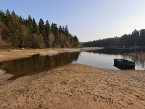 A small boat floats on the the Pierre-Percee lake, eastern France, Wednesday, March 1, 2023. France recorded 32 days without rain this winter – the longest such winter drought since record-keeping began in 1959. Around France, residents are sharing images of dried-up riverbeds or shrunken lakes – shocking sights in the depths of winter.