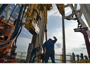 A floor hand signals to the driller to pull the pipe from the mouse hole on Orion Drilling Co.'s Perseus drilling rig near Encinal in Webb County, Texas, U.S. The U.S. is pumping oil at the fastest pace in more than three decades, helped by a shale boom that's unlocked supplies from formations including the Eagle Ford in Texas and the Bakken in North Dakota.