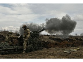 Ukrainian servicemen fire with a 105mm howitzer towards Russian positions on March 8. Photographer: Aris Messinis/AFP/Getty Images