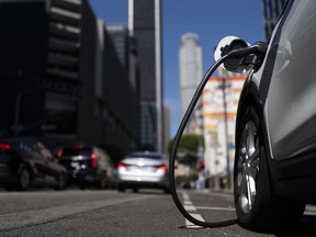 FILE - An electric vehicle is plugged into a charger in Los Angeles, Thursday, Aug. 25, 2022. Fewer new electric vehicles will qualify for a full $7,500 federal tax credit later this year, and many will get only half that under rules proposed Friday, March 30, 2023, by the U.S. Treasury Department. The rules are required under last year's Inflation Reduction Act.