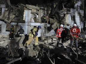 Ukrainian State Emergency Service firefighters inspect a damaged house after Russian shelling hit in Zaporizhzhia, Ukraine, Thursday, March 2, 2023.