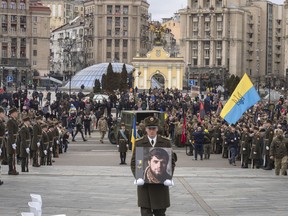 A serviceman carry a photo of Ukrainian officer Dmytro Kotsiubaylo, code-named "Da Vinci", during a commemoration ceremony in Independence Square in Kyiv, Ukraine, Friday, March 10, 2023. Kotsiubaylo was killed three days ago in a battle near Bakhmut in the Donetsk region.