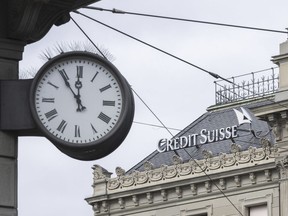 Five to twelve "fuenf vor zwoelf" is written on a clock next to a logo of the Swiss bank Credit Suisse, in Zurich, Switzerland, Monday, March 20, 2023. Shares of Credit Suisse plunged 60.5% on Monday after banking giant UBS said it would buy its troubled Swiss rival for almost $3.25 billion in a deal orchestrated by regulators to try to stave off further turmoil in the global banking system.