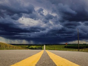 Storm clouds build over a highway in southern Alberta near the town of Carstairs on Monday, July 4, 2016. Tourmaline Oil Corp. says it will partner with California-based Clean Energy Fuels Corp. to build and operate a network of compressed natural gas (CNG) fuelling stations along highway corridors in Western Canada.