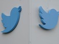 Twitter logos hang outside the company's offices in San Francisco.