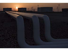 The sun rises beyond oil storage tanks at the Enbridge Inc. Cushing storage terminal in Cushing, Oklahoma, U.S., on Wednesday, March 25, 2015.  Photographer: Daniel Acker/Bloomberg