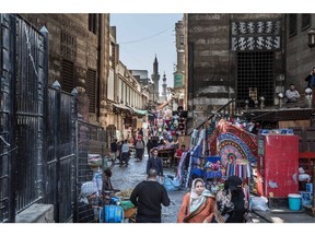 Pedestrians pass among market stalls in Cairo, Egypt on March 31, 2018. Egyptian President Abdel-Fattah El-Sisi was set to sweep to victory with more than 90 percent of the vote in this week's election, crushing his one token challenger after credible competitors were eliminated before the contest.