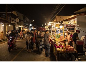 Tourists browse a night market in Pai, Mae Hong Soon Province, Thailand, on Monday, Nov. 15, 2021. Thailand's economy last quarter suffered a smaller contraction than expected, with the Southeast Asian nation on track to rebound from the worst of the pandemic. Photographer: Andre Malerba/Bloomberg