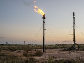 A flare burns off unused natural gas in Andrews County, Texas, US, on Tuesday, Sept. 28, 2021. America's oil communities have deep financial ties to the fossil fuel industry. Now even in the midst of a price boom, local governments have to start deciding when to tackle plans for the looming clean energy transition. Photographer: Matthew Busch/Bloomberg