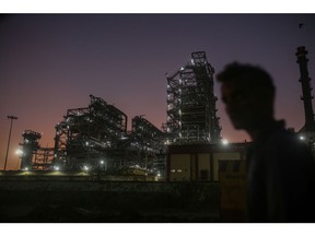 A pedestrian walks past an oil refinery, operated by Bharat Petroleum Corp. Ltd., in Mumbai, India, on Saturday, Dec. 10, 2022. A senior official at India's oil ministry told reporters this month India has been buying oil from about 30 countries, and will continue to buy from anywhere including Russia beyond January. Photographer: Dhiraj Singh/Bloomberg