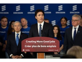 François-Philippe Champagne, left, watches Justin Trudeau speak during a news conference in Ottawa on April 17.