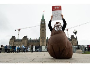 A member of the Public Service Alliance of Canada holds up a placard on the first day of a national strike in Ottawa last week. Photographer: James Park/Bloomberg