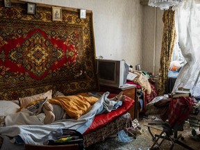 The body of a woman that died after a Russian attack at a residential area lies on a bed surrounded by debris in Uman, central Ukraine, Friday, April 28, 2023.