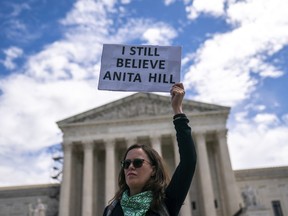 A protester holds a sign reading "I still believe Anita Hill" during a Planned Parenthood rally in support of abortion access outside the Supreme Court on Saturday, April. 15, 2023, in Washington.