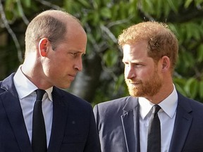FILE - Britain's Prince William and Britain's Prince Harry walk beside each other after viewing the floral tributes for the late Queen Elizabeth II outside Windsor Castle, in Windsor, England, Saturday, Sept. 10, 2022. Court papers say that Prince William quietly received "a very large sum of money" in a 2020 phone hacking settlement with the British newspaper arm of Rupert Murdoch's media empire. Court documents aired Tuesday in one of his brother's lawsuits against British newspapers says the Prince of Wales, heir to the British throne, quietly received a settlement in 2020.