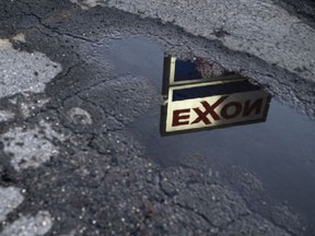 Exxon Mobil Corp. signage is reflected in a puddle at a gas station in Ohio.