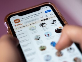 A person navigates the Temu website on a smartphone in Toronto, Tuesday, April 4, 2023. Temu launched in Canada in early February, the same month it aired a Super Bowl ad with the tagline "shop like a billionaire," and offers consumers an alternative to online juggernaut Amazon.