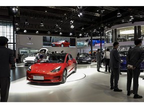 Visitors walk past Chinese-made Tesla Inc. electric vehicles at the company's booth at the Auto Shanghai 2021 show in Shanghai, China, on Monday, April 19, 2021. The Shanghai International Automobile Industry Exhibition kicked off on Monday in China's financial hub, a multiday event aimed at showcasing the best and brightest car innovations in the world's biggest vehicle market. Photographer: Qilai Shen/Bloomberg