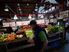 A person shops for produce at the Granville Island Market in Vancouver.