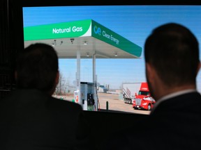 Guests watch a video detailing the announcement of a $70 million joint development agreement between Tourmaline Oil Corp. and Clean Energy Fuels Corp. to build CNG stations in Western Canada.