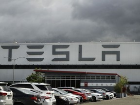 FILE - Vehicles are parked outside the Tesla plant, in Fremont, Calif., on May 12, 2020. A federal jury on Monday, April 3, 2023, has awarded nearly $3.2 million in damages to a former Black worker at a Tesla factory California that has been at the epicenter of racial discrimination allegations hanging over the automaker run by billionaire Elon Musk.