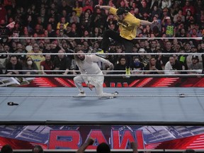 File - Wrestler Logan Paul, right, kicks Seth "Freakin" Rollins during the WWE Monday Night RAW event, Monday, March 6, 2023, in Boston. WWE and the company that runs Ultimate Fighting Championship will combine to create a $21.4 billion sports entertainment company.