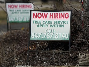 A hiring sign for tree care service work is posted in Wheeling, Ill., Sunday, March 19, 2023. On Thursday, the Labor Department reports on the number of people who applied for unemployment benefits last week.