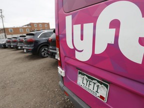 FILE - A Lyft ride-hailing vehicle is parked near Empower Field at Mile High in Denver on April 30, 2020.