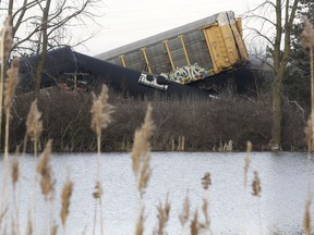 FILE - Multiple cars of a Norfolk Southern cargo train lie toppled on one another after derailing at a train crossing near Springfield, Ohio, on March 4, 2023. Federal regulators are warning railroads Thursday, April 27, that the long trains they favor can cause all kinds of problems and contribute to derailments, so they want the railroads to ensure their training and operating procedures account for that.