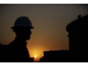 The sun sets beyond crude oil storage tanks at the Juaymah tank farm at Saudi Aramco's Ras Tanura oil refinery and oil terminal in Ras Tanura, Saudi Arabia, on Monday, Oct. 1, 2018. Photographer: Simon Dawson/Bloomberg