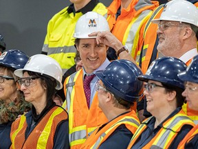 Prime Minister Justin Trudeau, centre, stands for a photo with Vital Metals employees after his tour of the rare earths element processing plant in Saskatoon in January, 2022.
