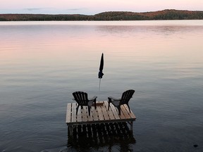 Muskoka chairs sit on a dock looking over Boshkung Lake, in Algonquin Highlands, Ont., Monday, Oct. 5, 2020.
