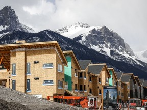 Mountains loom behind homes under construction in Canmore, Alta., Monday, April 24, 2023.THE CANADIAN PRESS/Jeff McIntosh