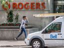 Un piéton passe devant l'immeuble Rogers à Toronto.