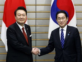FILE - South Korean President Yoon Suk Yeol, left, and Japanese Prime Minister Fumio Kishida shake hands ahead of their bilateral meeting at the prime minister's office in Tokyo, March 16, 2023. South Korea on Monday, April 24, 2023 has formally restored Japan to its list of countries it gives preferential treatment in trade, three years after the neighbors downgraded each other's trade status amid a diplomatic row over historical grievances.