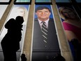 People pass by a promo of Fox News host Tucker Carlson on the News Corporation building in New York, in 2019.