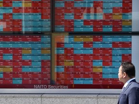 A man looks at an electronic stock board showing Japan's stock prices at a securities firm on April 4, 2023 in Tokyo. Asian stock markets followed Wall Street higher on Friday, April 7, ahead of a U.S. job market update that traders hope might encourage the Federal Reserve to ease off plans for more interest rate hikes.