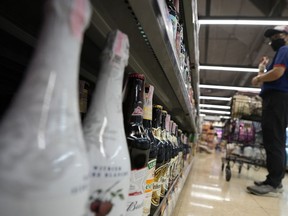 A customer looks at beer on shelves at a supermarket in Bangkok, Thailand, Monday, April 24, 2023. Thai beer enthusiast Artid Sivahansaphan said Monday he has been handed a 150,000 baht ($4,360) fine and a suspended six-month prison sentence for violating a law on advertising alcoholic beverages by posting a photo of an IPA-style beer with his evaluation of it on Facebook.