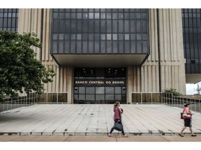 Pedestrians pass in front of the Central Bank of Brazil headquarters in Brasilia, Brazil on Wednesday, Jan. 18, 2017. Foreign direct investment in Brazil soared to a six-year high in December as investors abroad kept an optimistic view of the country's long-term prospects, the central bank said. Photographer: Gustavo Gomes/Bloomberg