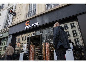 Pedestrians pass a Courir footwear store in Paris, France, on Tuesday, Oct. 23, 2018. Rallye SA, the parent of French retailer Casino Guichard-Perrachon SA, received a 283 million-euro ($325 million) bid for its shoe chain Courir from Equistone Partners Europe, which could help the embattled company to reduce debt.