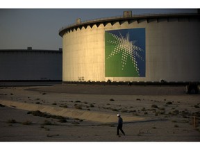 An employee walks past crude oil storage tanks at the Juaymah Tank Farm in Saudi Aramco's Ras Tanura oil refinery and oil terminal in Ras Tanura, Saudi Arabia, on Monday, Oct. 1, 2018.  Photographer: Simon Dawson/Bloomberg