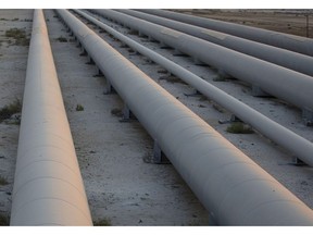 An employee walks along a pipeline carrying crude oil from the Juaymah Tank Farm in Saudi Aramco's Ras Tanura oil refinery and oil terminal in Ras Tanura, Saudi Arabia, on Monday, Oct. 1, 2018.  Photographer: Simon Dawson/Bloomberg