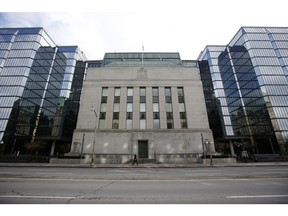 A pedestrian walks past the Bank of Canada building in Ottawa, Ontario, Canada, on Wednesday, Oct. 28, 2020. The Bank of Canada said the country's economy wont fully absorb slack in the economy before 2023, suggesting it will keep rates at near zero for the next few years.