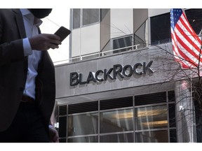 A pedestrian holding a smartphone passes in front of BlackRock Inc. headquarters in New York, U.S, on Tuesday, April 13, 2021. BlackRock Inc. is scheduled to release earnings figures on April 15.