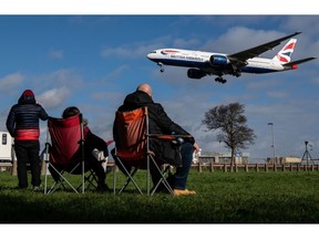 Plane spotters watch a passenger airplane, operated by British Airways, a unit of International Consolidated Airlines Group SA (IAG), coming in to land at London Heathrow Airport in London, U.K., on Wednesday, Feb. 23, 2022. IAG are due to report results on Friday.