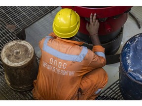 A worker inspects a land drilling oil rig, manufactured by Megha Engineering and Infrastructures Ltd. (MEIL) and operated by Oil and Natural Gas Corp., during a media tour in Bhimavaram, Andhra Pradesh, India, on Tuesday, March 8, 2022. MEIL has supplied 10 land drilling oil rigs to ONGC, with three already in operation, according to a company statement. Photographer: Sumit Dayal/Bloomberg