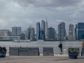 A visitor takes photographs of the Manhattan skyline from Gantry Plaza State Park in the Long Island City neighborhood in the Queens borough of New York, US, on Wednesday, Aug. 17, 2022. New York's apartment market has become super competitive as rent prices set records and vacancies stay low. Photographer: Ismail Ferdous/Bloomberg